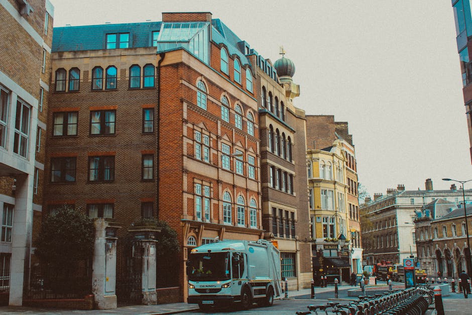 Photograph of a busy city street in Elephant and Castle with a historic multi-storey building featuring ornate architectural details, balconies, and a central dome visible on the left side. Below the 